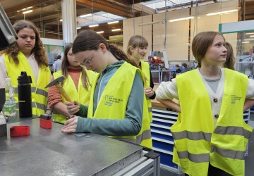 Ein paar Schülerinnen sind gerade bei einer Aktiv-Station und dürfen Metall bearbeiten