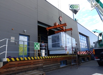 Die CNC-Fräsmaschine wird mittels Kran in eine Halle gehoben.