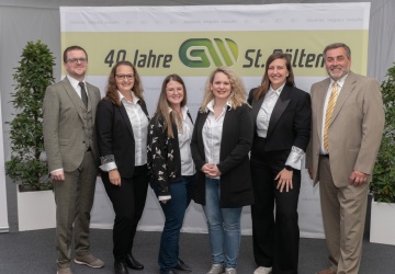 6 Mitarbeiter der GW St.Pölten stehen vor einem Banner