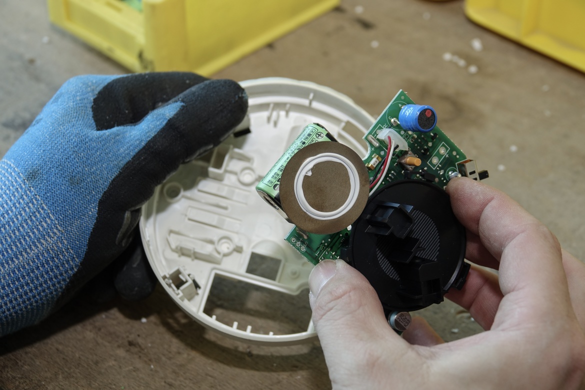 Detailaufnahme - es werden ein Kunststoffteil des Geh&auml;uses sowie die Platine in der Hand gehalten