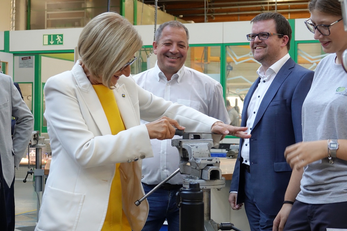 LH Johanna Mikl-Leitner in der Lehrwerkst&auml;tte, wie sie an einem Schraubstock ihre Schleifk&uuml;nste ausprobiert