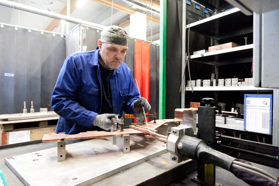 Mitarbeiter bei Induktivlötarbeiten an einer Kupferschiene