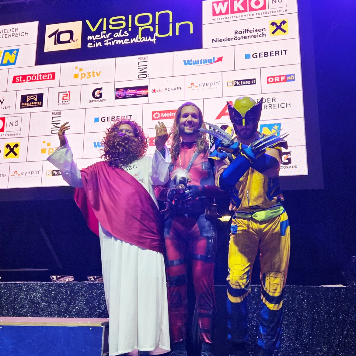Gruppenfoto des 3er Männerteams, sie haben den dritten Platz erlangt und halten ihren Pokal voller Freude in den Händen - in den Verkleidungen Deadpool, Wolverine und Jesus.
