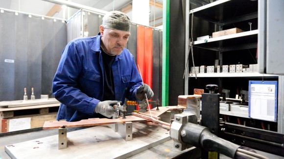 Mitarbeiter bei Induktivlötarbeiten an einer Kupferschiene