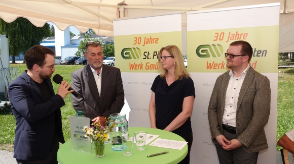 Andreas Onea moderiert das Interview mit Gerhard Nachförg, Andrea Fillek und Michael Wölfl; sie stehen vor Rollups mit der Aufschrift "30 Jahre GW St. Pölten - Werk Gmünd"