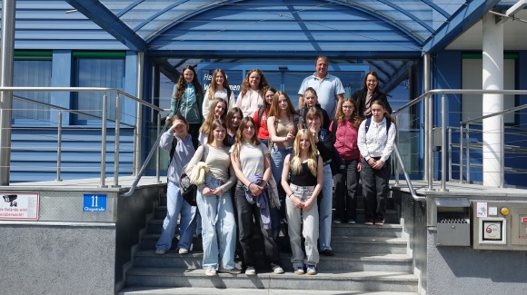 Gruppenfoto der GW-Mitarbeiter*innen und Sch&uuml;lerinnen vor dem Haupteingang der GW