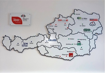 Schild in Form einer Österreich-Landkarte mit Logos und Standorten